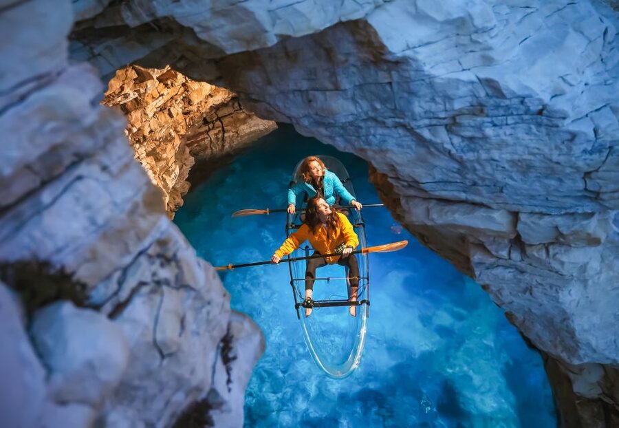 Pula: Night-Time Sea Kayaking Tour in Transparent Kayak - Entering the cave in a lit kayak